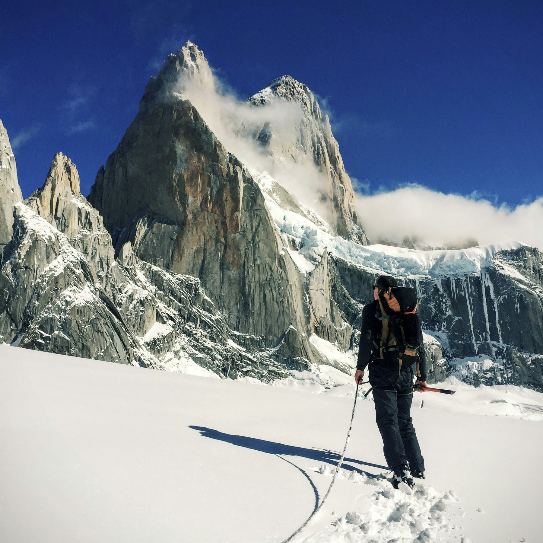 Alpiniste au pied d'un sommet enneigé